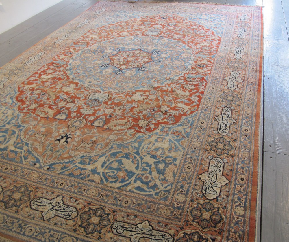An antique Persian Tabriz carpet featuring a central medallion surrounded by floral motifs in terracotta and pale blue with calligraphic border cartouches. View III