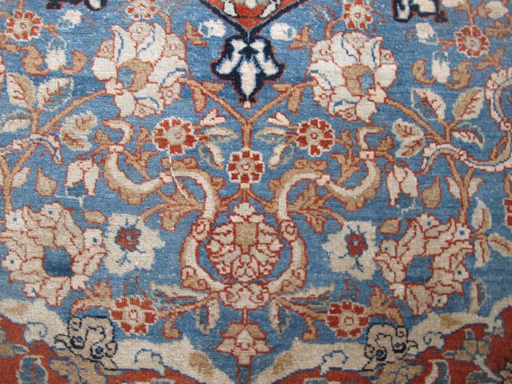 An antique Persian Tabriz carpet featuring a central medallion surrounded by floral motifs in terracotta and pale blue with calligraphic border cartouches. View V