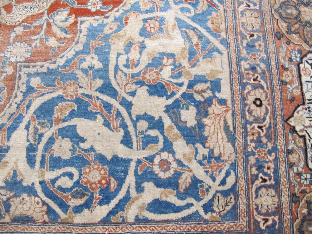 An antique Persian Tabriz carpet featuring a central medallion surrounded by floral motifs in terracotta and pale blue with calligraphic border cartouches. View VI