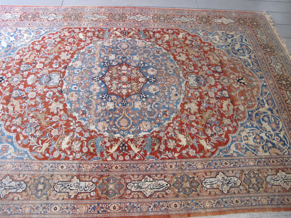 An antique Persian Tabriz carpet featuring a central medallion surrounded by floral motifs in terracotta and pale blue with calligraphic border cartouches. View X