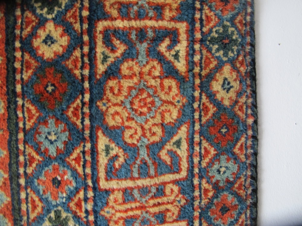 An antique Persian Tabriz wool rug featuring a light blue central field filled with repeating geometric floral motifs surrounded by multi-tiered terracotta and navy borders. View VIII