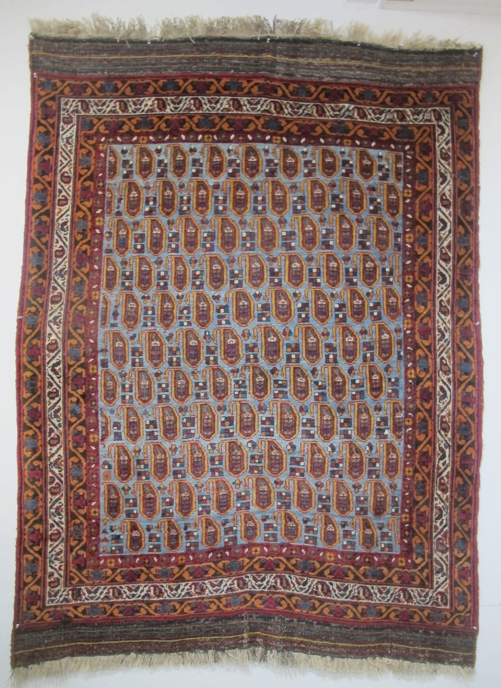 An antique hand-knotted Persian Afshar wool rug featuring repeating boteh motifs on a light blue field with multi-band patterned borders.
