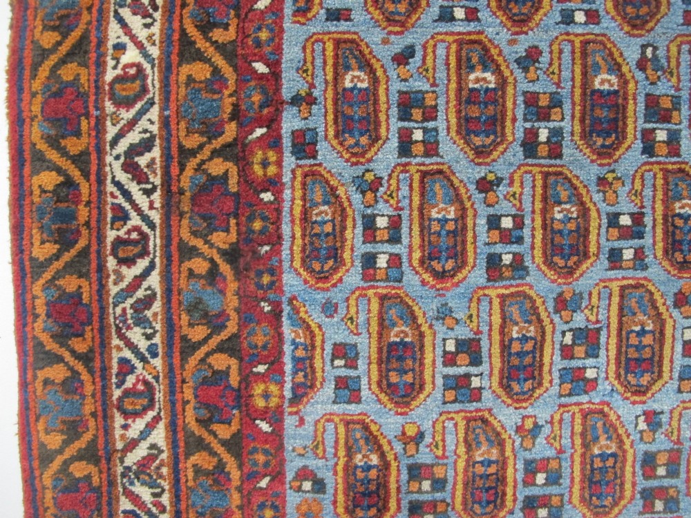 An antique hand-knotted Persian Afshar wool rug featuring repeating boteh motifs on a light blue field with multi-band patterned borders. View III
