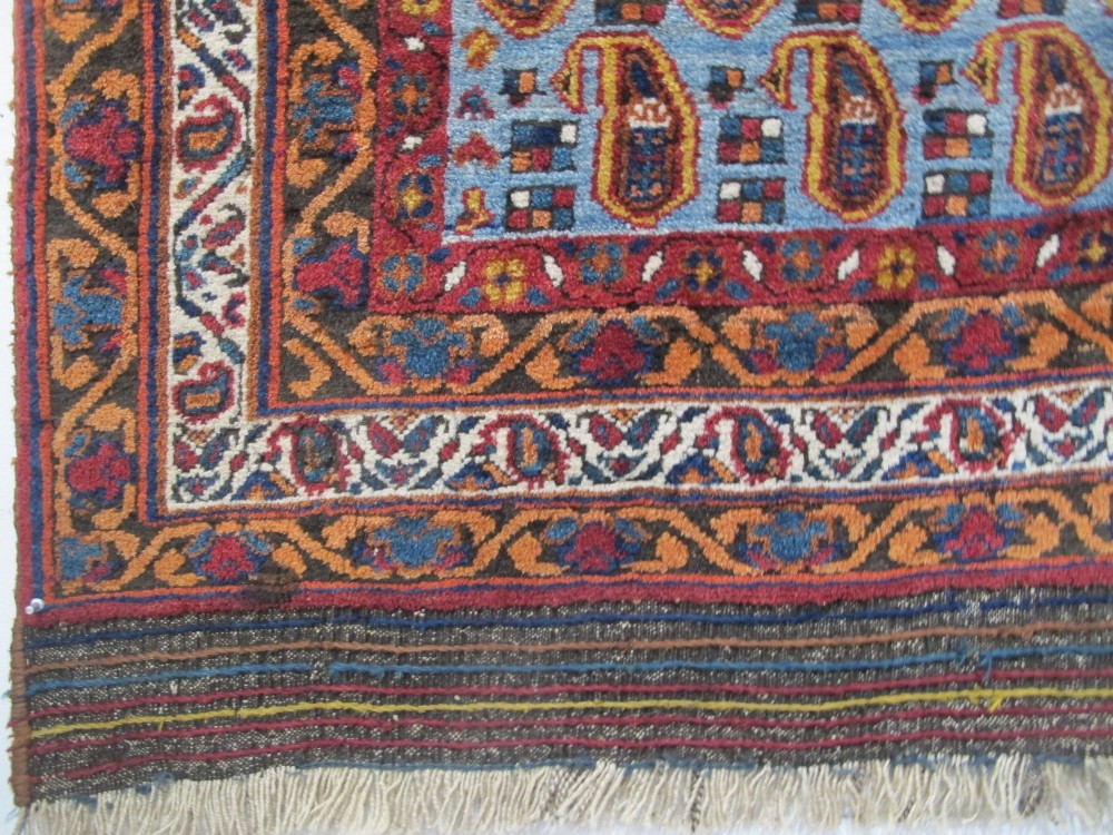 An antique hand-knotted Persian Afshar wool rug featuring repeating boteh motifs on a light blue field with multi-band patterned borders. View IV