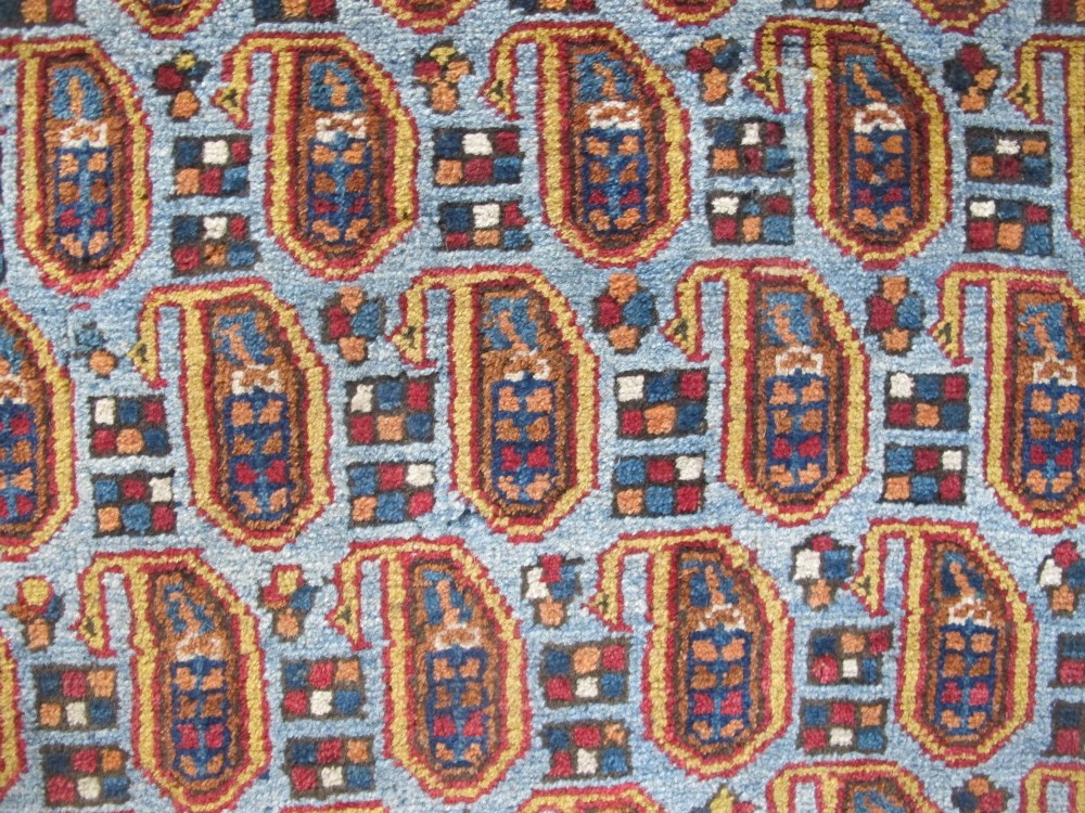 An antique hand-knotted Persian Afshar wool rug featuring repeating boteh motifs on a light blue field with multi-band patterned borders. View V