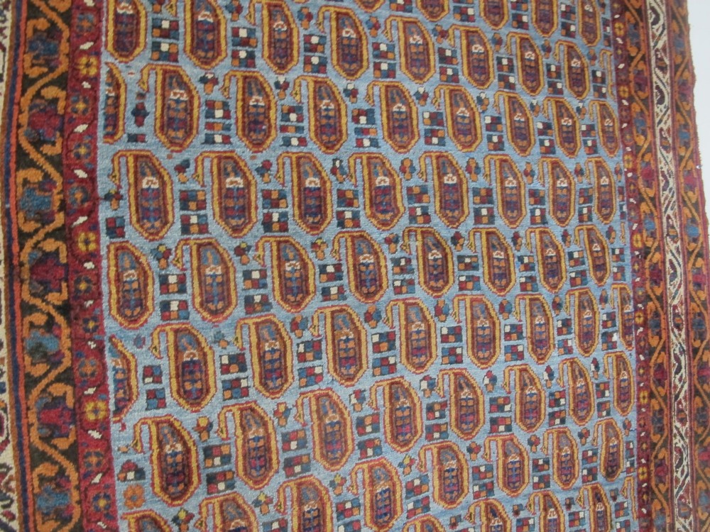An antique hand-knotted Persian Afshar wool rug featuring repeating boteh motifs on a light blue field with multi-band patterned borders. View IX