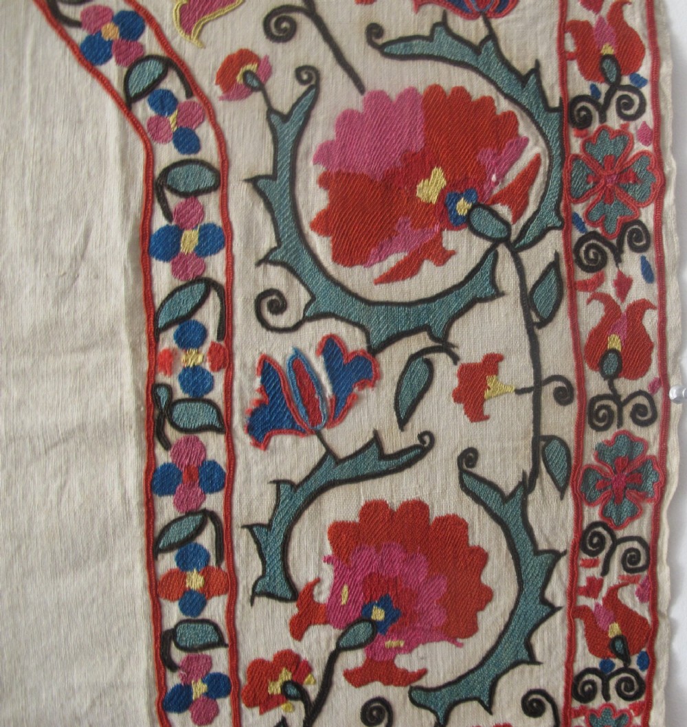 An antique cream cotton suzani textile embroidered with an architectural arch and red floral vines with teal leaves. View VII