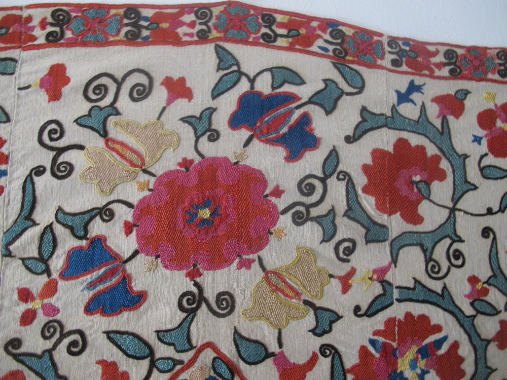 An antique cream cotton suzani textile embroidered with an architectural arch and red floral vines with teal leaves. View XIV