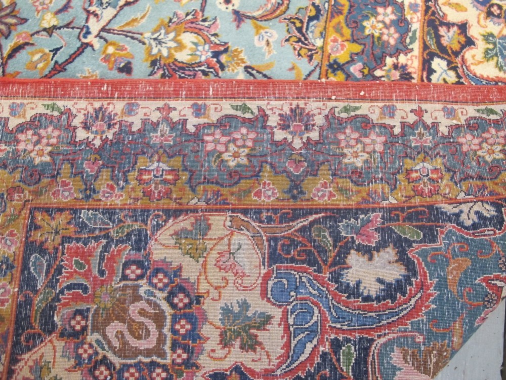 An early twentieth-century hand-knotted Persian Kashan wool carpet featuring a reddish central medallion on a light blue field surrounded by a navy floral border. View VIII