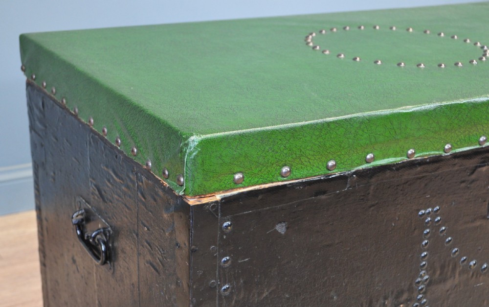 A rectangular Victorian pine kist chest featuring a black painted exterior decorated with brass studwork and a green padded top. View III