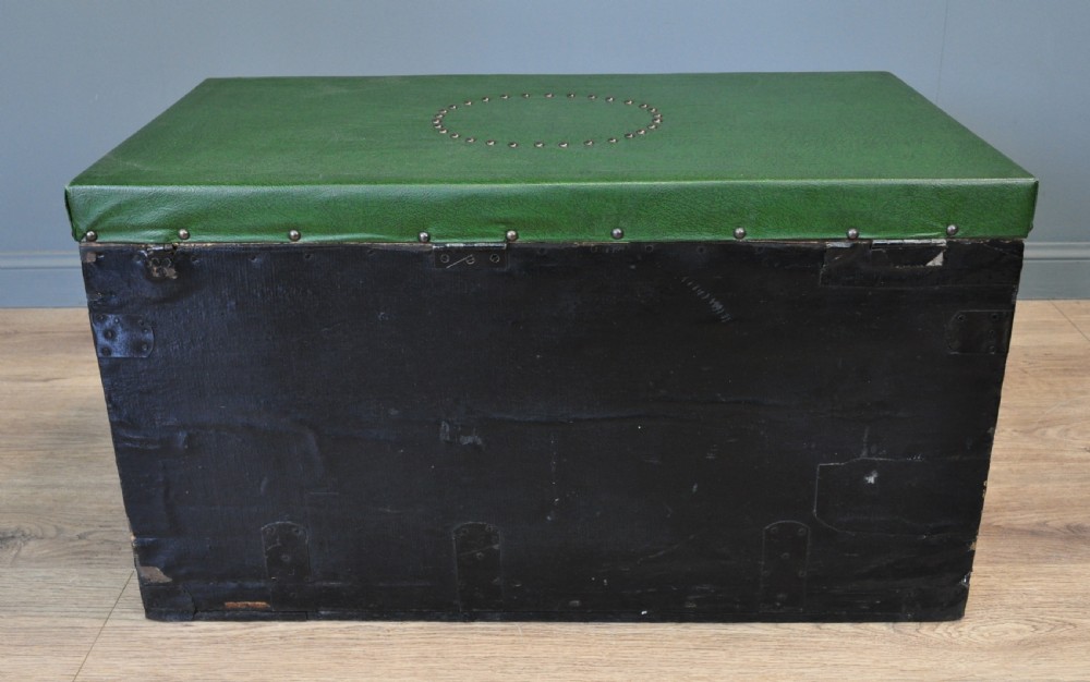 A rectangular Victorian pine kist chest featuring a black painted exterior decorated with brass studwork and a green padded top. View X