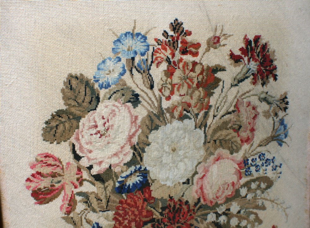A Victorian rosewood fire screen with a carved top cresting framing a central floral needlepoint tapestry panel. View V