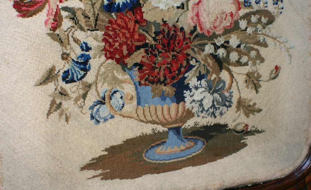 A Victorian rosewood fire screen with a carved top cresting framing a central floral needlepoint tapestry panel. View VI
