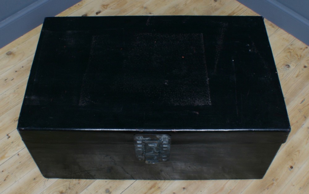 A large rectangular black lacquered oriental pigskin shipping trunk featuring a central metal latch plate. View XI