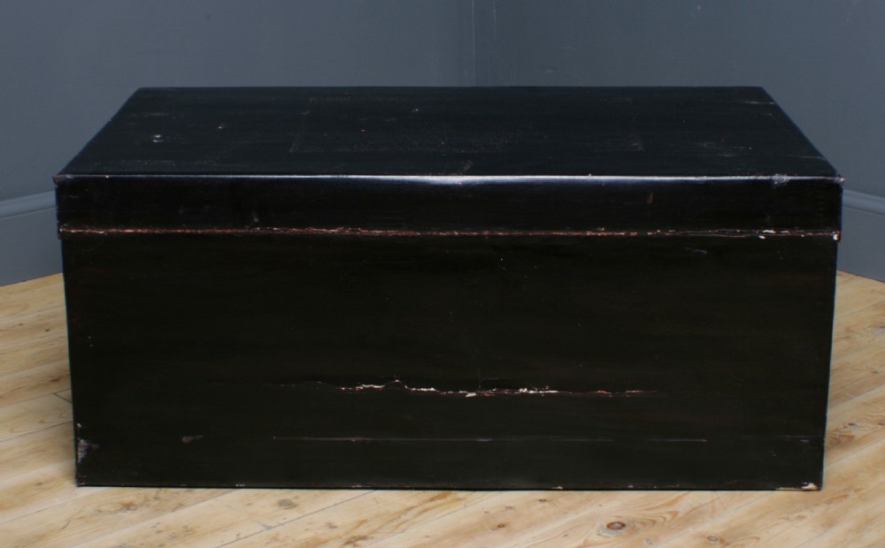 A large rectangular black lacquered oriental pigskin shipping trunk featuring a central metal latch plate. View XII