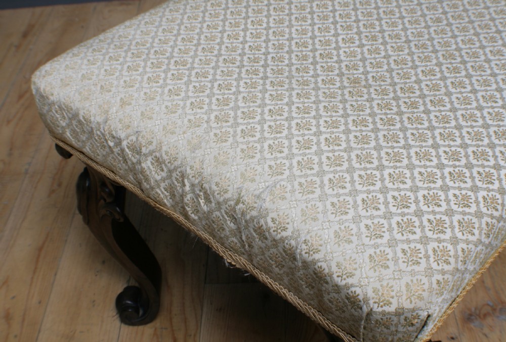 A Victorian rosewood footstool with carved cabriole legs and a cream patterned fabric seat. View VII