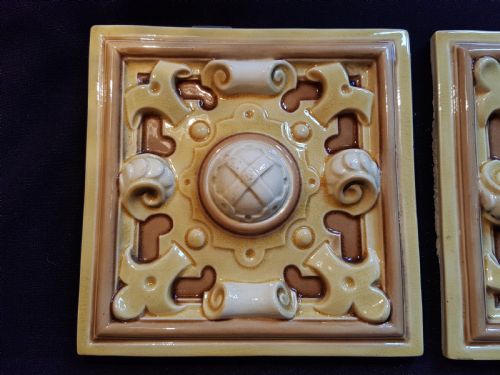 fig 1. A set of six Victorian square earthenware tiles featuring high-relief moulded scrollwork and central cabochons in ochre and brown glazes.