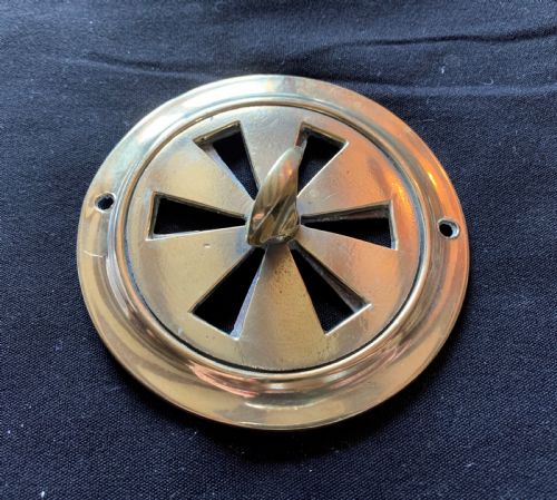 fig 1. A circular solid brass Victorian hit-and-miss air vent with a central turning handle, triangular slotted openings, and two mounting screw holes.