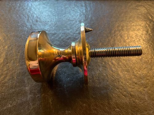 fig 1. A polished bronze Edwardian centre door knob featuring a circular stepped backplate and a threaded rear fixing bolt.
