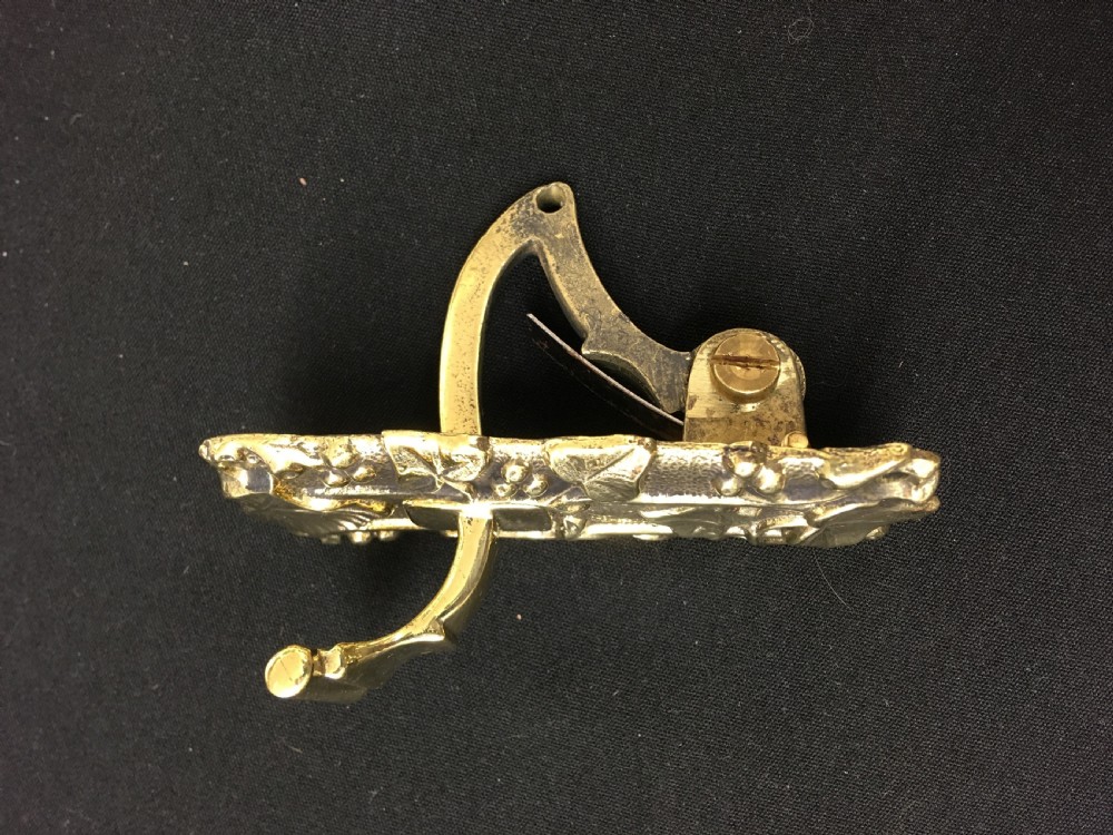 A cast brass Victorian door bell pull featuring intricate relief ivy leaf and berry detailing with a central mechanical lever. View II