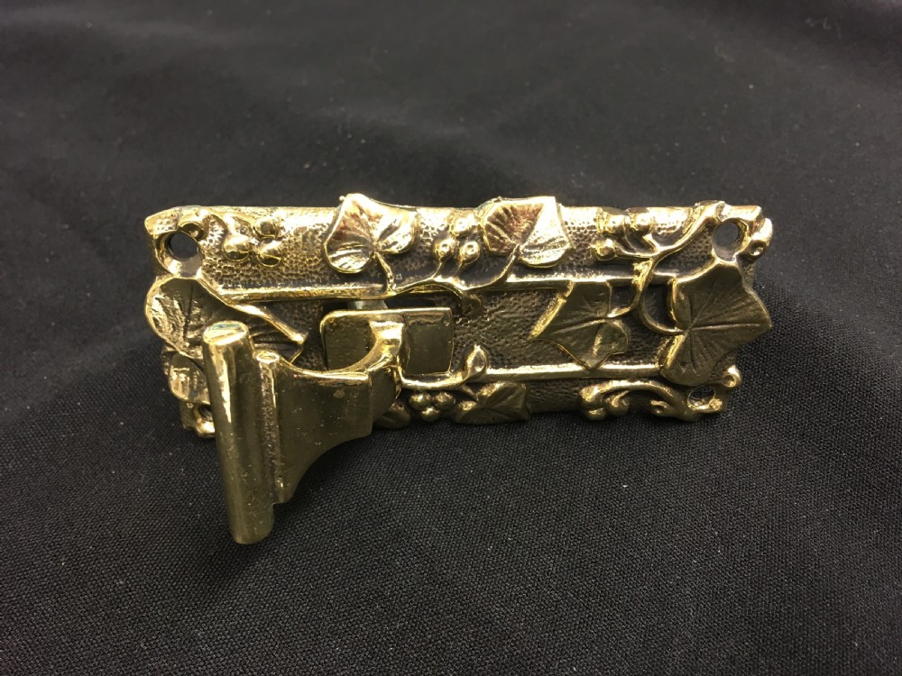 A cast brass Victorian door bell pull featuring intricate relief ivy leaf and berry detailing with a central mechanical lever. View IV