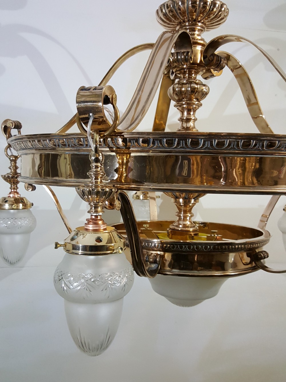 A Victorian style polished bronze and brass ceiling light fixture featuring a central ring frame with scrolled upper supports and frosted cut glass shades. View V