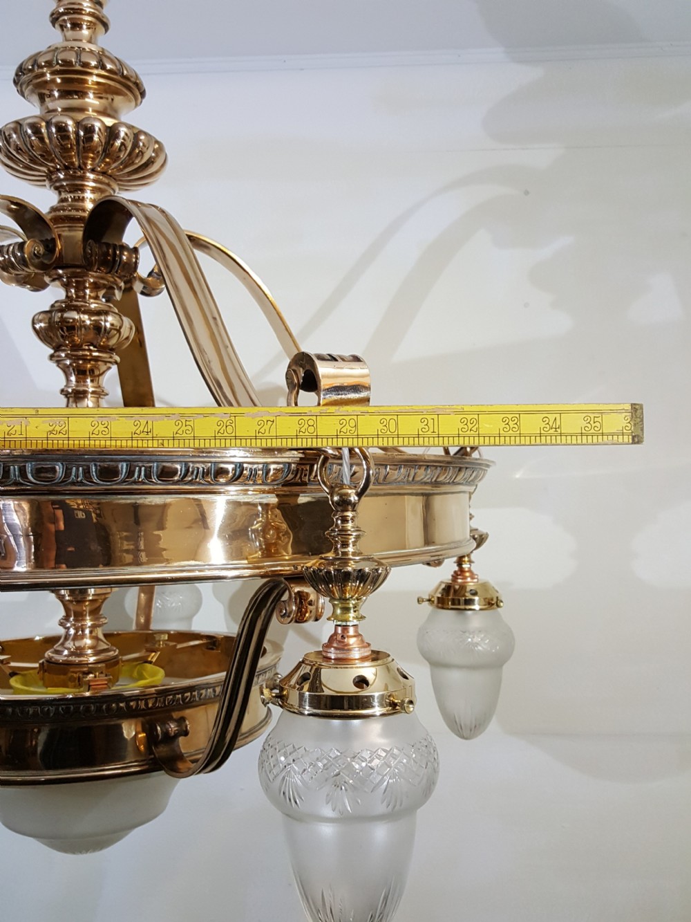 A Victorian style polished bronze and brass ceiling light fixture featuring a central ring frame with scrolled upper supports and frosted cut glass shades. View IX