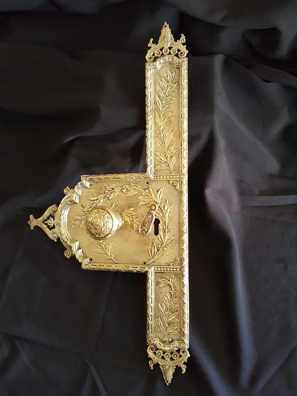 An ornate Regency period cast brass door plate featuring raised botanical leaf decoration, a round decorative door knob, a keyhole escutcheon, and ornate cresting. View VIII