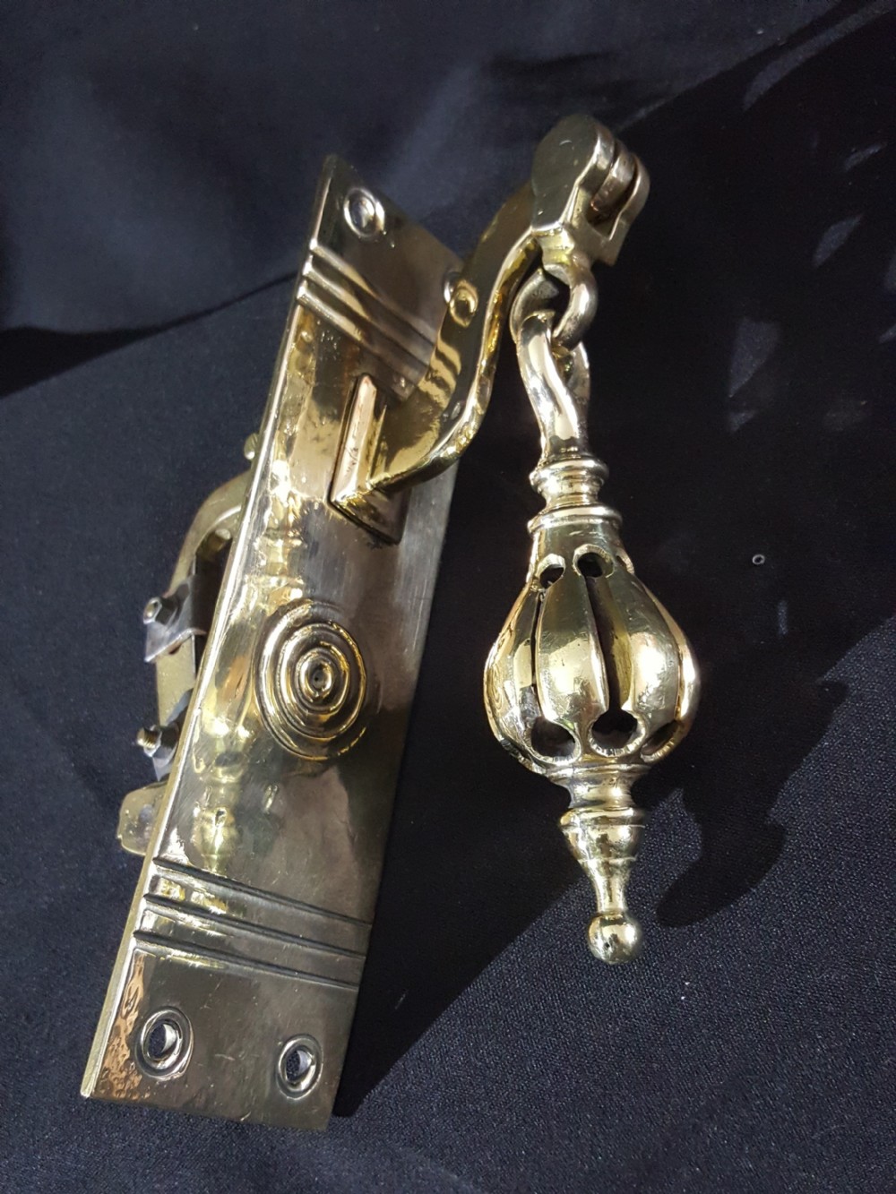 A polished brass Georgian style pull bell mechanism featuring an openwork teardrop handle and rectangular backplate with mounting holes. View IV