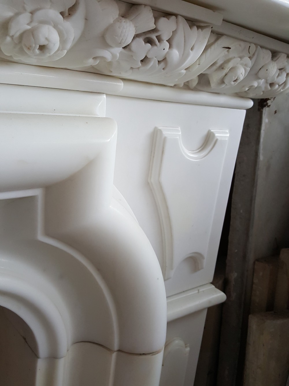 A carved white statuary marble Victorian fireplace surround featuring an ornate floral frieze and moulded arched jambs. View IV