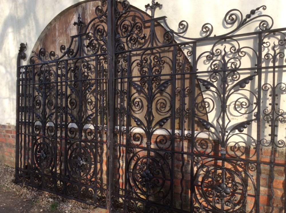 A pair of large black Victorian wrought iron driveway gates featuring ornate scrollwork, circular medallions, and decorative top finials. View II