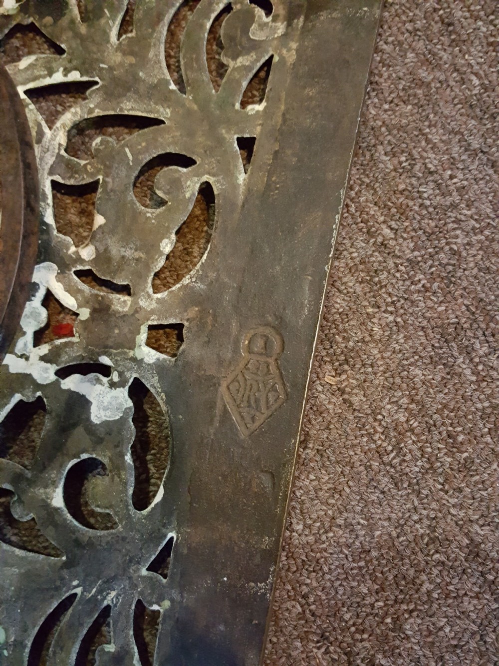 A Georgian pierced brass hearth footman featuring acanthus foliage scrollwork, side carrying handles, and shaped front cabriole legs. View II