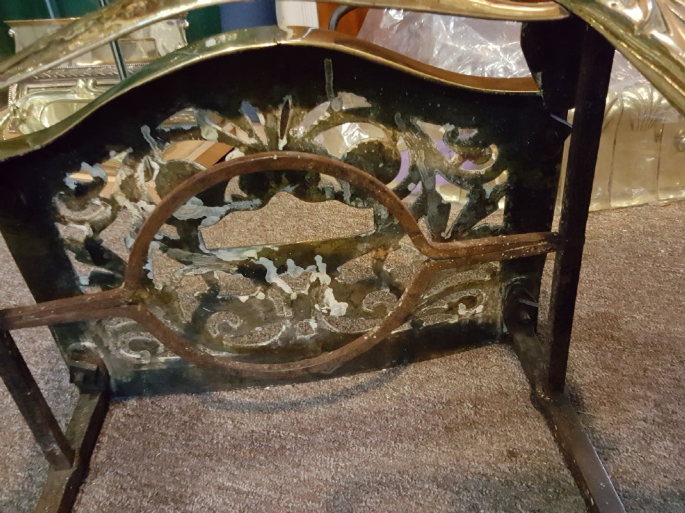 A Georgian pierced brass hearth footman featuring acanthus foliage scrollwork, side carrying handles, and shaped front cabriole legs. View III