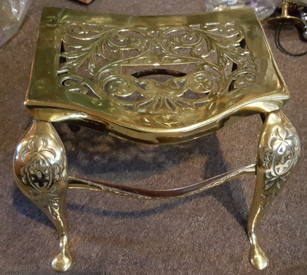A Georgian pierced brass hearth footman featuring acanthus foliage scrollwork, side carrying handles, and shaped front cabriole legs. View VI