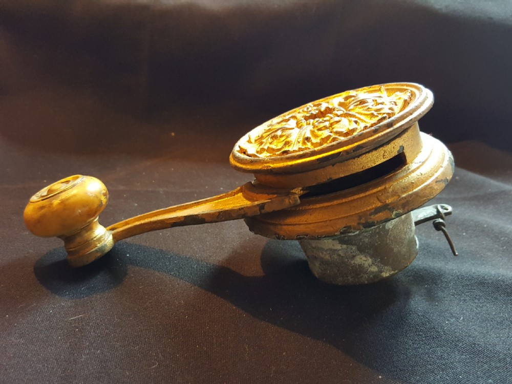 An ornate Georgian gilt brass mechanical bell pull featuring a circular carved floral rosette and a curved lever arm. View III