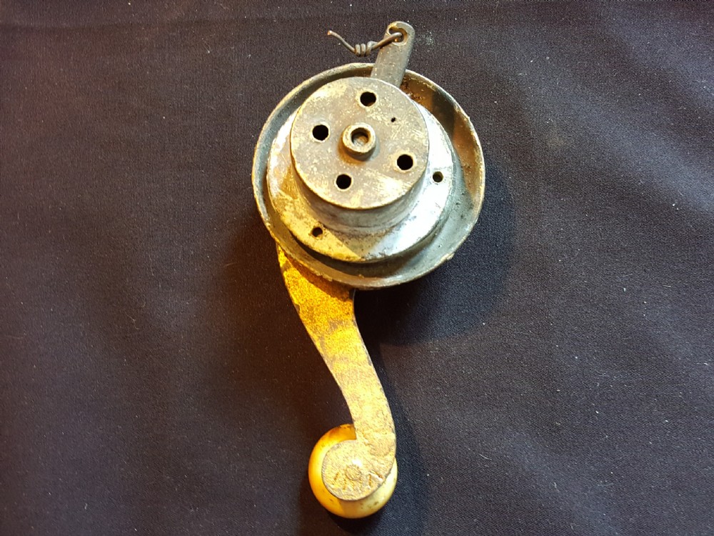 An ornate Georgian gilt brass mechanical bell pull featuring a circular carved floral rosette and a curved lever arm. View IV