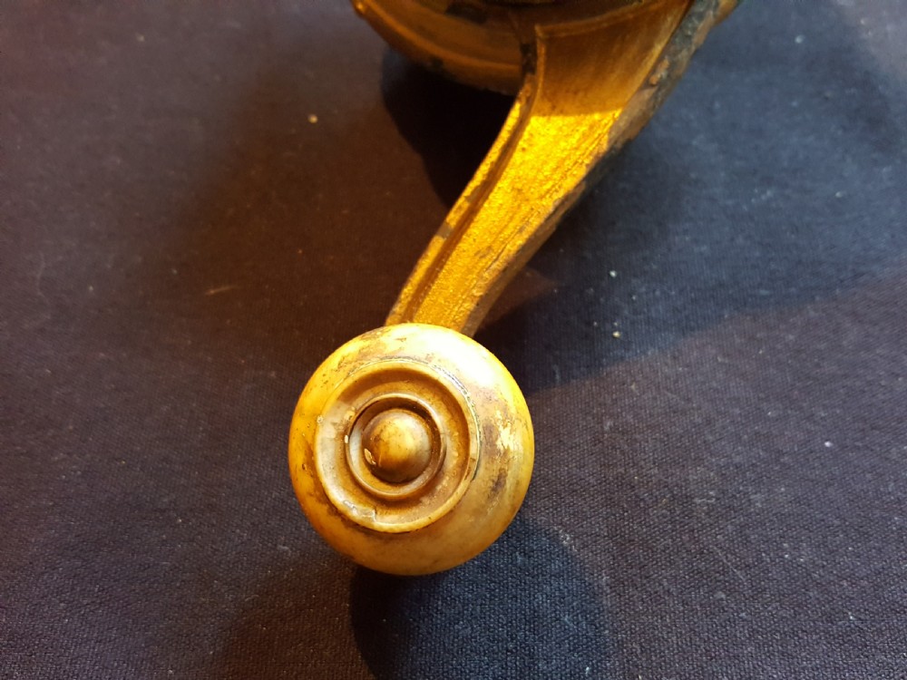 An ornate Georgian gilt brass mechanical bell pull featuring a circular carved floral rosette and a curved lever arm. View VI