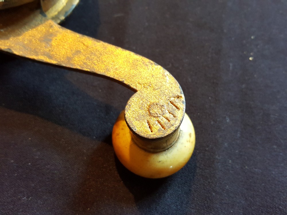 An ornate Georgian gilt brass mechanical bell pull featuring a circular carved floral rosette and a curved lever arm. View VII