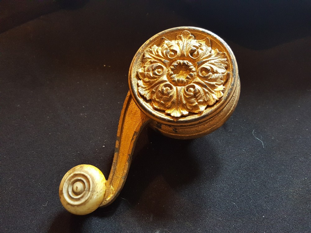 An ornate Georgian cast brass servant bell lever featuring a carved leaf rosette backplate and a turned horn handle. View II