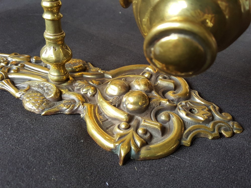 An ornate Victorian solid brass mechanical door bell pull featuring a faceted knob, rod lever mechanism, and cast foliate backplate. View III