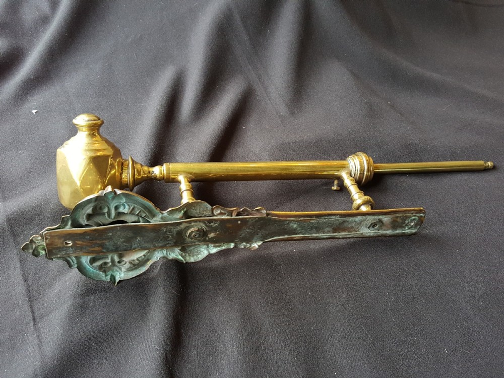 An ornate Victorian solid brass mechanical door bell pull featuring a faceted knob, rod lever mechanism, and cast foliate backplate. View VII