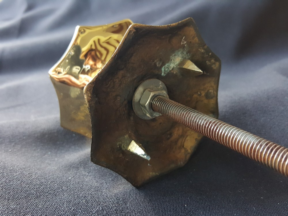 A polished brass centre door knob featuring a multi-fluted star shape with an attached threaded mounting bolt. View VII
