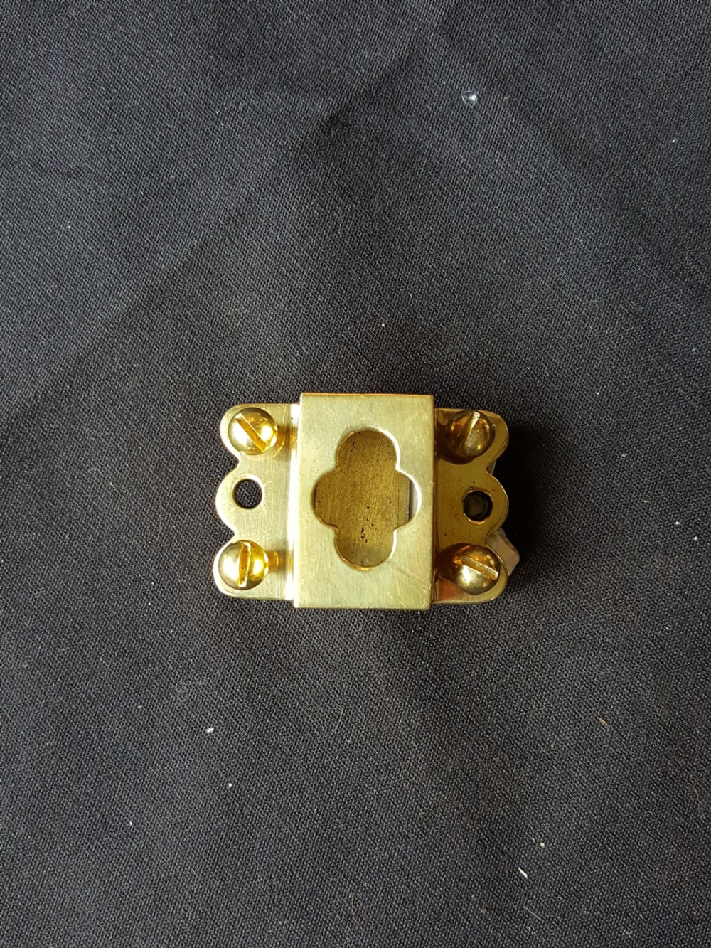 A Victorian Gothic Revival solid brass surface door bolt with a decorative shaped backplate, trefoil cutouts, and a matching keeper. View III