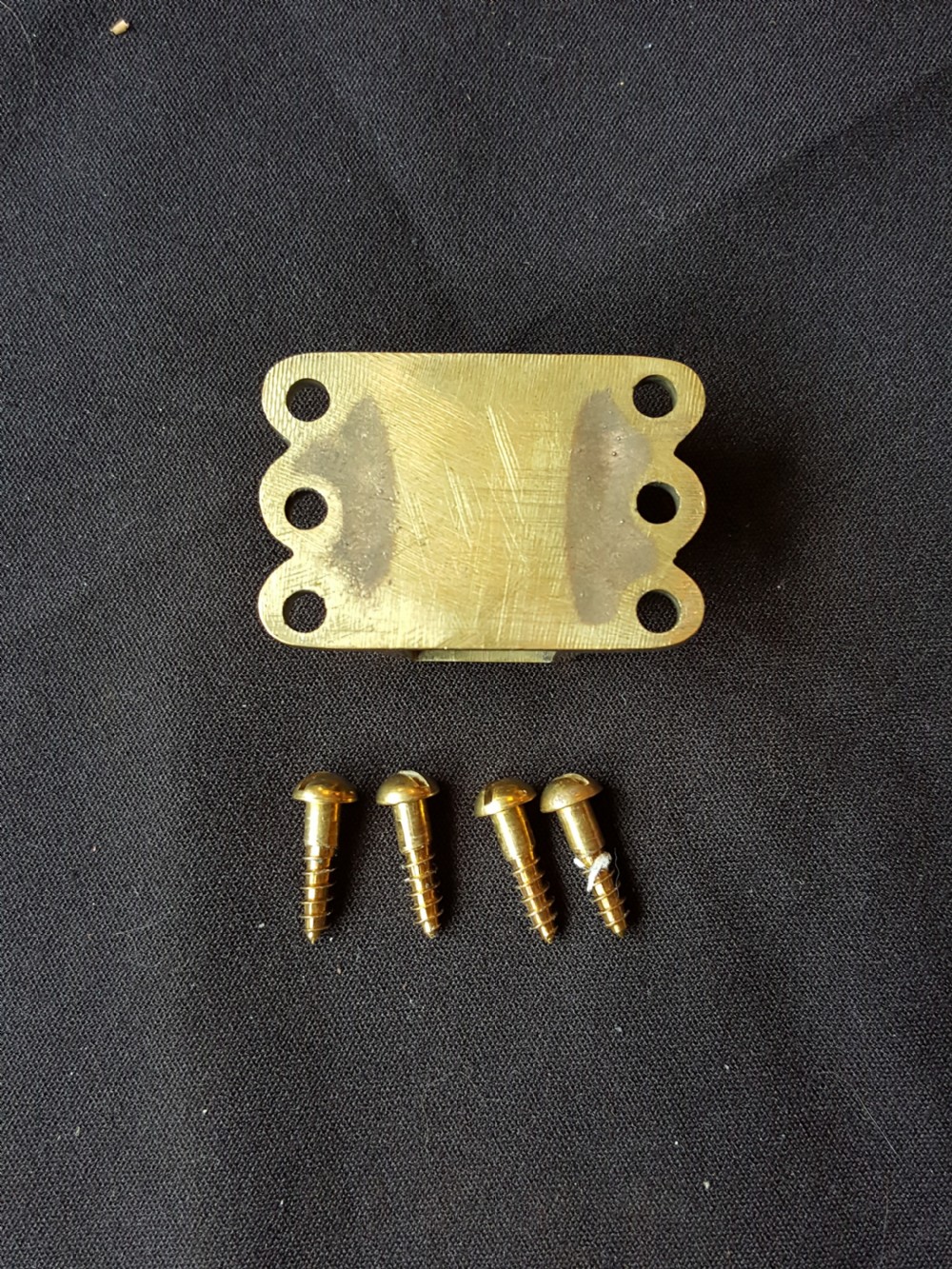 A Victorian Gothic Revival solid brass surface door bolt with a decorative shaped backplate, trefoil cutouts, and a matching keeper. View V