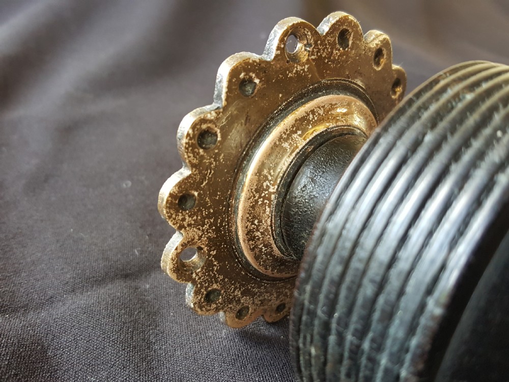 A Victorian centre door knob featuring a turned black ebony head with concentric circular grooves attached to a scalloped brass rose. View IV