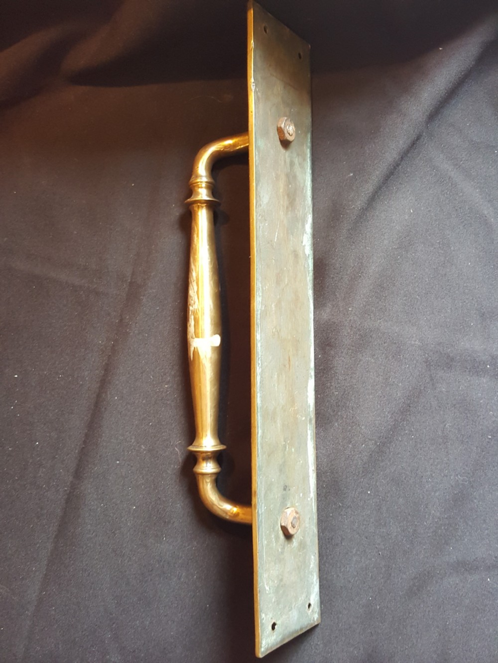 A solid brass Edwardian door pull handle mounted on a rectangular backplate with four corner mounting holes. View II
