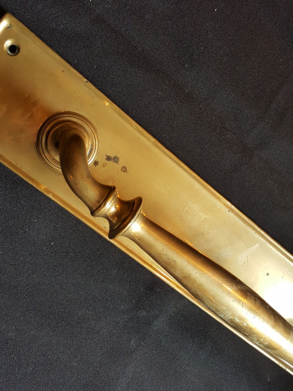 A solid brass Edwardian door pull handle mounted on a rectangular backplate with four corner mounting holes. View V