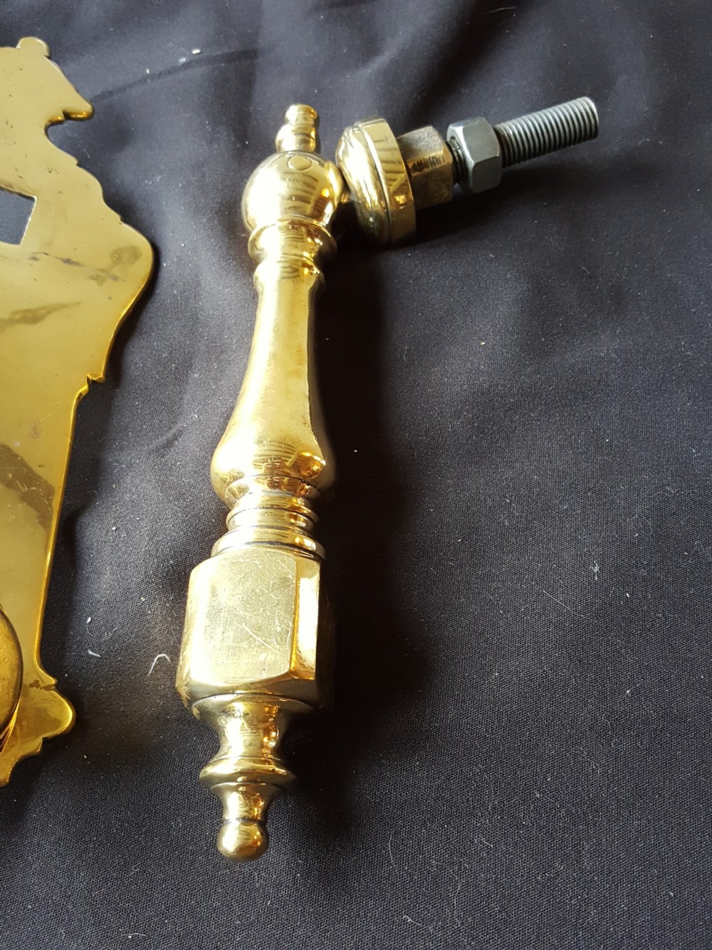 A two-piece Victorian polished brass door knocker comprising a shaped backplate with a striking stud and a turned baluster-style knocker with a threaded bolt. View III