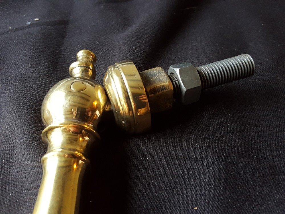 A two-piece Victorian polished brass door knocker comprising a shaped backplate with a striking stud and a turned baluster-style knocker with a threaded bolt. View IV