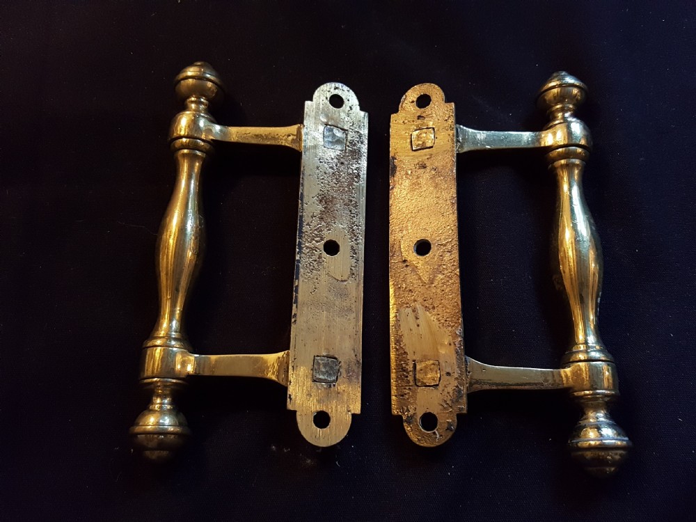 A pair of cast Victorian brass sash lifts featuring turned baluster handles with finials attached to flat mounting plates with screw holes. View III